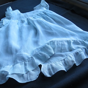 Lovely old little ruffled dress in sky blue Swiss veil. The dress is open behind; the bodice is embroidered with a seedling of flowers
