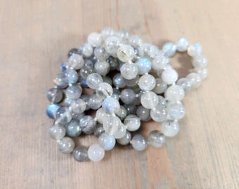 May include: A strand of round, iridescent labradorite beads in shades of gray and white.