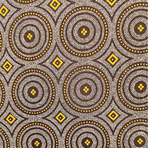 May include: A brown fabric with a repeating pattern of white and yellow circles. The circles are made up of small white dots and have a yellow outline. There are also small yellow diamonds scattered throughout the fabric.