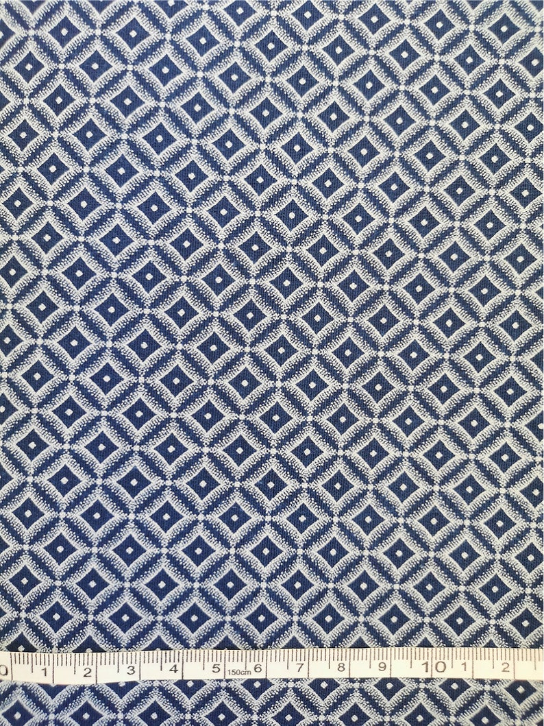 May include: Blue fabric with a white diamond pattern. The fabric is measured with a ruler in inches.