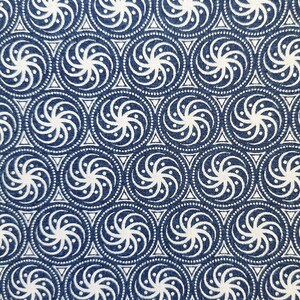 May include: A blue fabric with a white repeating pattern of swirling circles. The fabric is measured with a ruler in inches.