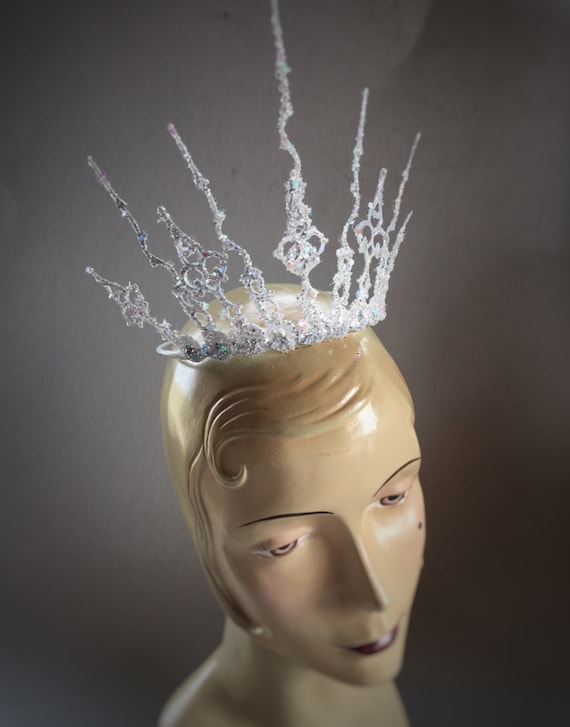 Winter wonderland Ice Queen style over the top crown for your awesome event. Securely attaches with a skinny elastic strap tucked under the hair at the back of the neck.