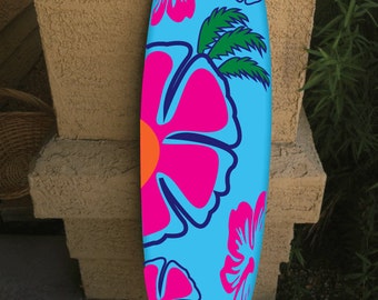 May include: A blue surfboard with a pink, orange, and green floral design. The surfboard is decorated with hibiscus flowers and palm leaves.