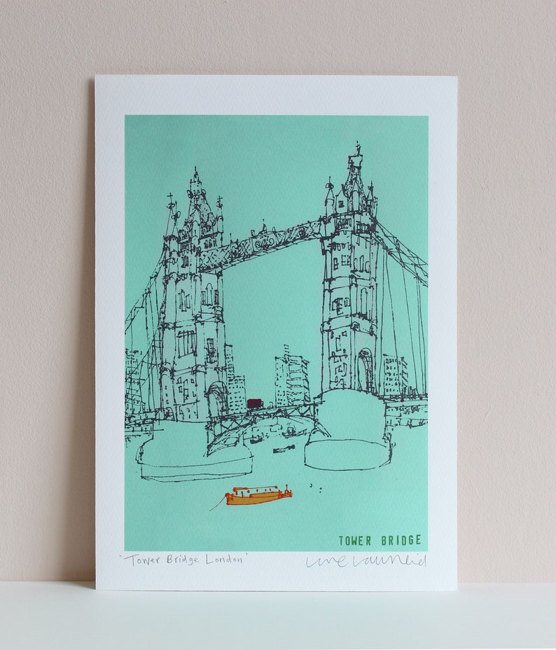 May include: A black and white line drawing of Tower Bridge in London, England. The bridge is drawn in a simple style with a turquoise background. The text "Tower Bridge London" and "Line Drawn" is written below the bridge.