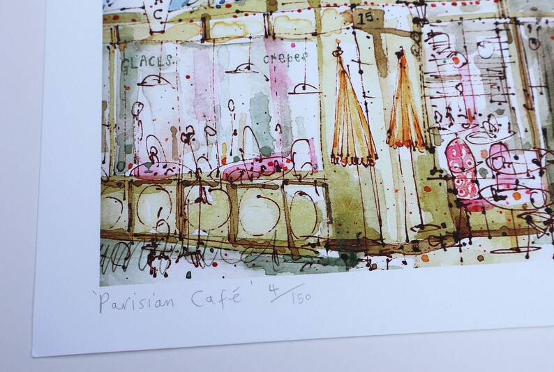 May include: A watercolor painting of a Parisian cafe scene with the text 'Parisian Cafe' and '4/150' in the bottom right corner. The painting features a cafe with tables, chairs, and umbrellas. The cafe is painted in a light and airy style, with a focus on the details of the cafe's interior.