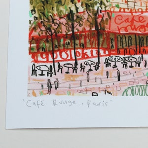 May include: A colorful illustration of a cafe in Paris, France. The cafe is called "Cafe Rouge" and is depicted with red, green, and yellow colors. The illustration is drawn in a childlike style with simple lines and shapes.
