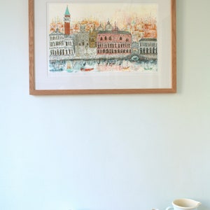 May include: A framed watercolor painting of a cityscape with a tall building and a bridge over a canal. The painting is in shades of pink, blue, and green.