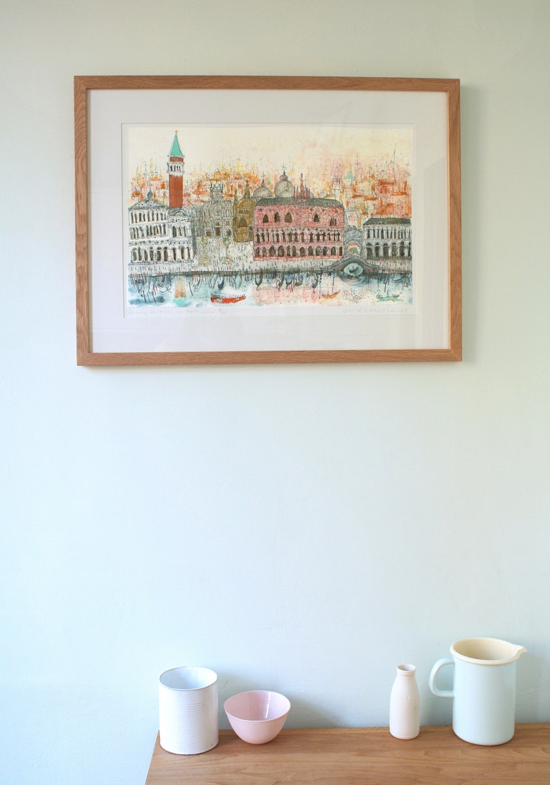 May include: A framed watercolor painting of a cityscape with a tall building and a bridge over a canal. The painting is in shades of pink, blue, and green.