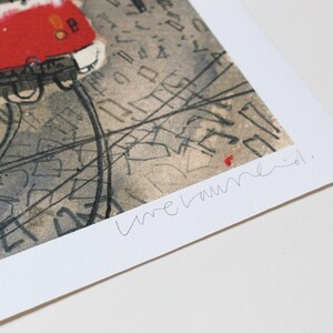 May include: A black and white print of a red tram with a handwritten signature that says "une laune."