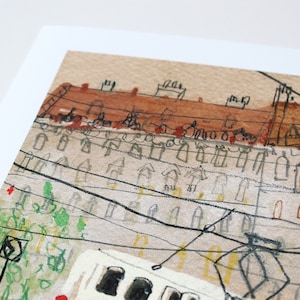 May include: A watercolor painting of a city scene with a tram in the foreground. The tram is white with black windows and is surrounded by buildings with red roofs. The buildings are drawn in a simple style with black lines and brown watercolor washes. There are power lines running across the scene.