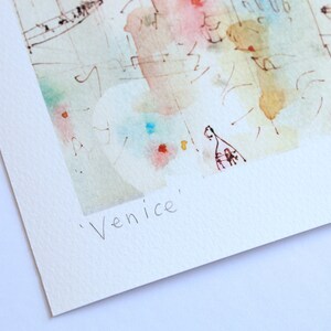 May include: A watercolour painting of Venice, Italy. The painting is in shades of blue, green, pink, and yellow. The text 'Venice' is written in black ink at the bottom of the painting.