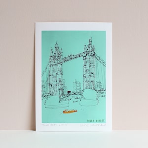 May include: A black and white line drawing of Tower Bridge in London, England. The bridge is drawn on a turquoise background. The text "Tower Bridge" and "Live, Love, London" are written below the bridge.