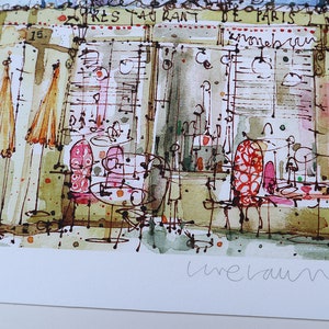 May include: A watercolor painting of a Parisian cafe with the text "Crepes" and "Restaurant de Paris" on the building. The cafe has red and white striped chairs and tables with umbrellas outside. The painting is signed "Line Vautrin" in the bottom right corner.