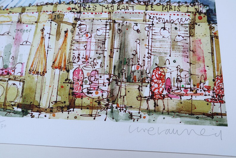 May include: A watercolor painting of a Parisian cafe with the text "Crepes" and "Restaurant de Paris" on the building. The cafe has red and white striped chairs and tables with umbrellas outside. The painting is signed "Line Vautrin" in the bottom right corner.