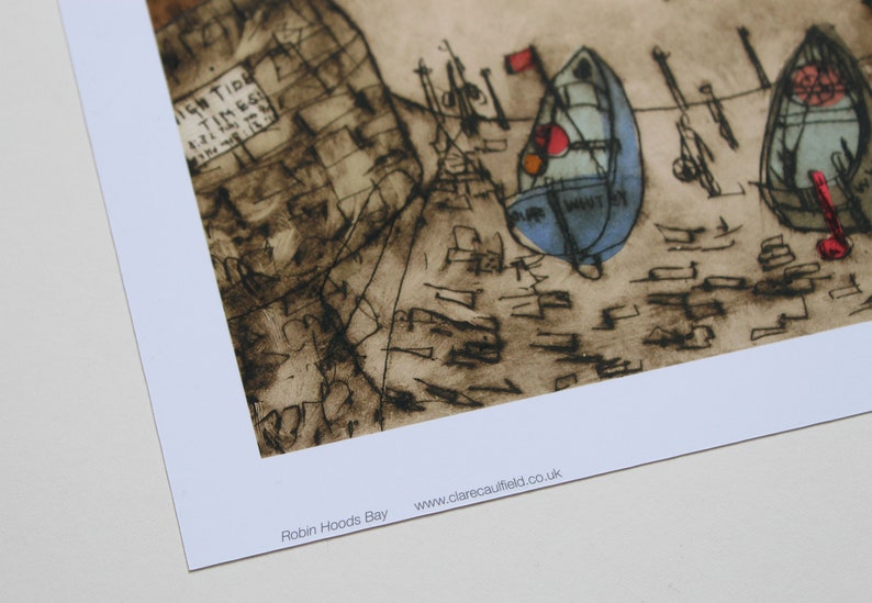 May include: A black and white ink drawing of a seascape with boats and the text "Robin Hoods Bay" and "www.clarecaulfield.co.uk".