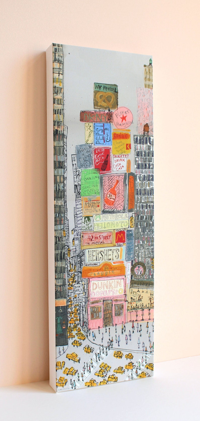 May include: A colorful illustration of a city street scene with tall buildings and many signs. The signs include the names of businesses like Dunkin Donuts, Hershey's, and Planet Hollywood. There are also many yellow taxis and people walking on the street.