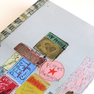 May include: A colorful illustration of a city scene with various signs and buildings. The signs include "Pepsi", "Planet Hollywood", "Kodak", "Phantom of the Opera", "Enjoy Coca Cola", "Heineken", "My Pretzel", and "Opening on Broadway".