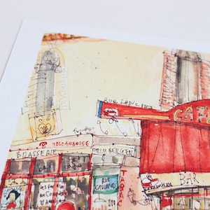 May include: Watercolor painting of a Parisian cafe, featuring a red awning with the words "CAFE des 2 Moulins". The artwork includes architectural details, street signs, and the text "Rue Lepic. paris". The style is loose and impressionistic.
