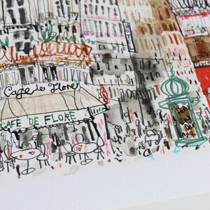 May include: A watercolor illustration of a Parisian street scene with a cafe called "Cafe de Flore" and a red building with the text "To La Cafe" in French. The illustration is done in a loose, sketchy style with black ink and watercolor washes.