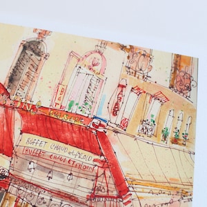 May include: Watercolor painting of a Parisian street scene with a red awning over a brasserie. The artwork features architectural details, including windows, signs, and the text "2 MOULINS BRASSERIE". The color palette includes red, yellow, and brown.