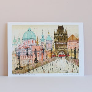May include: A watercolor painting of the Charles Bridge in Prague, Czech Republic. The painting features the iconic bridge towers, the Vltava River, and the city skyline in the background. The painting is signed "Loraine Levene" in the bottom right corner.