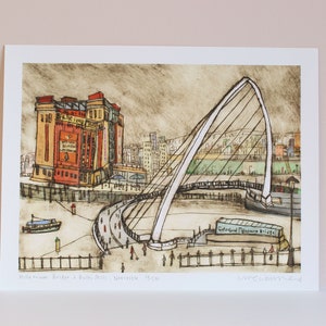 Puede incluir: Una ilustración en blanco y negro de un puente sobre un río con un edificio en el fondo. El puente se llama "The Gateshead Millennium Bridge" y el edificio se llama "The Baltic Mill".