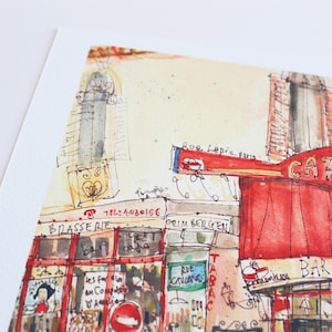 May include: Watercolor painting of a Parisian cafe with a red awning and the words "CAFE des 2 Moulins". The artwork includes the text "BRASSERIE", "TABAC", and "Rue Lepic, paris". The style is loose and impressionistic, with visible brushstrokes.