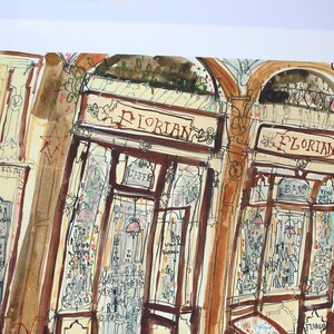Puede incluir: Una pintura de acuarela de una cafeter&iacute;a llamada "Florian" en Venecia, Italia. La cafeter&iacute;a tiene una fachada marr&oacute;n y blanca con un letrero que dice "Florian" en letras rojas. La cafeter&iacute;a tiene una gran ventana con un letrero que dice "Caffe" en letras blancas. La cafeter&iacute;a tiene una barra con un letrero que dice "Bar" en letras blancas. La cafeter&iacute;a tiene un letrero que dice "Vino Bianco" en letras blancas. La cafeter&iacute;a tiene un letrero que dice "Caffe" en letras blancas.