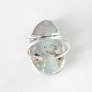 May include: Sterling silver ring with an oval shaped turquoise stone. The ring is marked "STERLING" on the back.