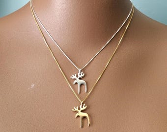 May include: Two layered necklaces featuring moose-shaped pendants. The top necklace is silver-toned with a silver moose charm, while the bottom necklace is gold-toned with a matching gold moose charm. Both chains are thin and delicate in style.