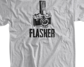 May include: A gray t-shirt with a black and white illustration of a camera with a flash. The text "FLASHER" is printed below the camera.