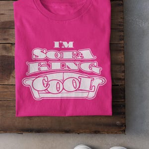 May include: A pink t-shirt with white text that reads "I'm Sofa King Cool" and a white outline of a couch.