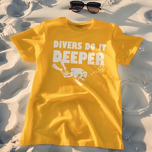 May include: A yellow t-shirt with the text "Divers Do It Deeper" in white lettering. A white silhouette of a scuba diver is below the text.