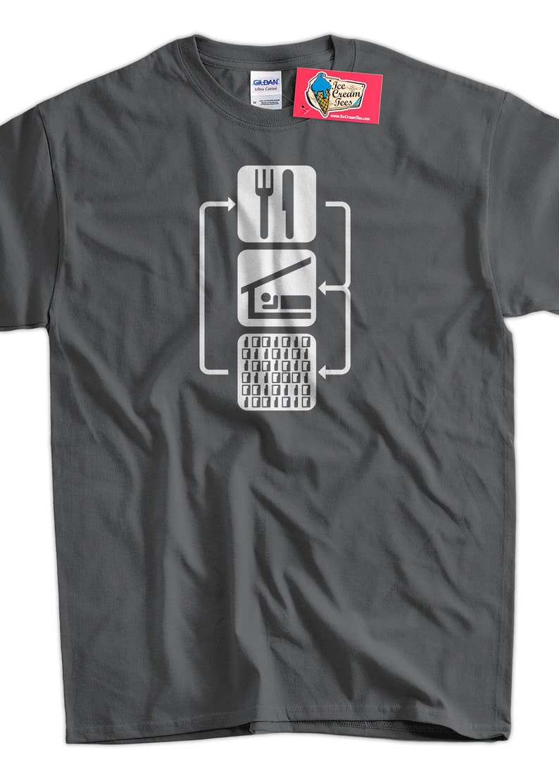 Peut inclure: Un t-shirt gris fonc&eacute; avec un graphique blanc d'un organigramme. L'organigramme montre trois &eacute;tapes&nbsp;: manger, dormir, coder. L'&eacute;tape de codage est repr&eacute;sent&eacute;e par une grille de uns et de z&eacute;ros.