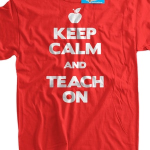 May include: Red t-shirt with white text that reads "Keep Calm and Teach On". A red apple with a green leaf is above the text.