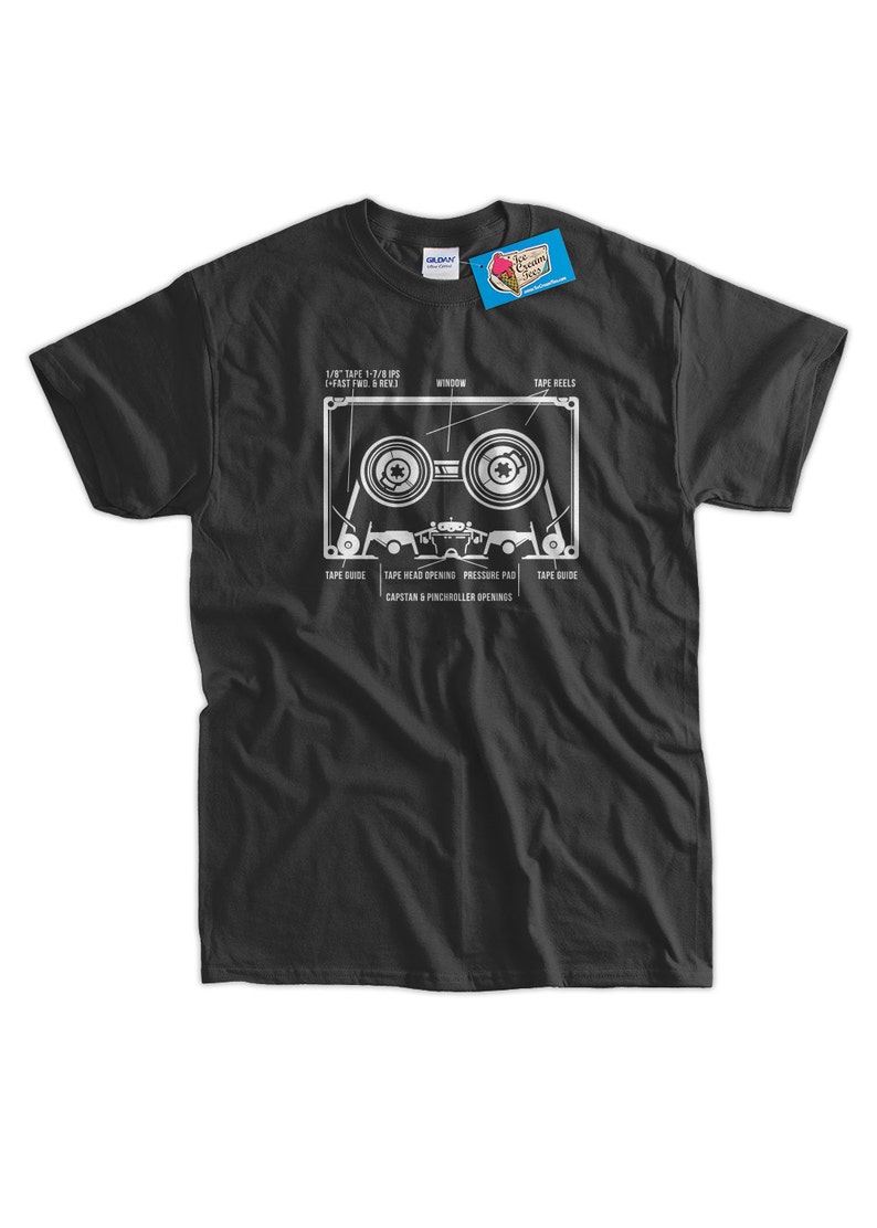 May include: A black t-shirt with a white graphic of a cassette tape. The graphic shows the different parts of the cassette tape, including the tape reels, window, tape head opening, pressure pad, and capstan & pinch roller openings.