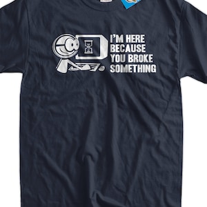 Peut inclure: Un t-shirt bleu foncé avec un graphique blanc d'un personnage de dessin animé tenant une loupe sur un écran d'ordinateur avec une icône de sablier. Le texte "Je suis là parce que vous avez cassé quelque chose" est imprimé sous le graphique.