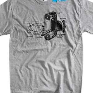 May include: A gray t-shirt with a black and white illustration of a vintage camera. The illustration shows the inner workings of the camera with labels for each part.