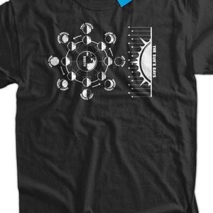 Może przedstawiać: Czarny T-shirt z białym nadrukiem przedstawiającym fazy księżyca i promienie słońca. Nadruk zawiera słowa "EARTH" i "THE SUN'S RAYS".