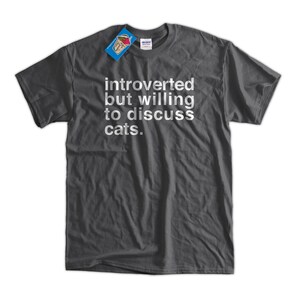 K&ouml;nnte beinhalten: Ein dunkelgraues T-Shirt mit dem Text "introvertiert, aber bereit, &uuml;ber Katzen zu diskutieren." in wei&szlig; gedruckt.