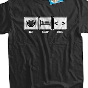 Peut inclure: T-shirt noir avec un graphique blanc qui dit "Manger, Dormir, Coder" avec des icônes représentant chaque mot.