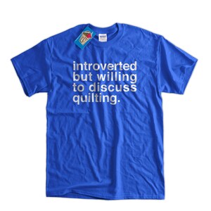 K&ouml;nnte beinhalten: Ein k&ouml;nigsblaues T-Shirt mit wei&szlig;em Text, der "introvertiert, aber bereit, &uuml;ber Quilten zu diskutieren" lautet.