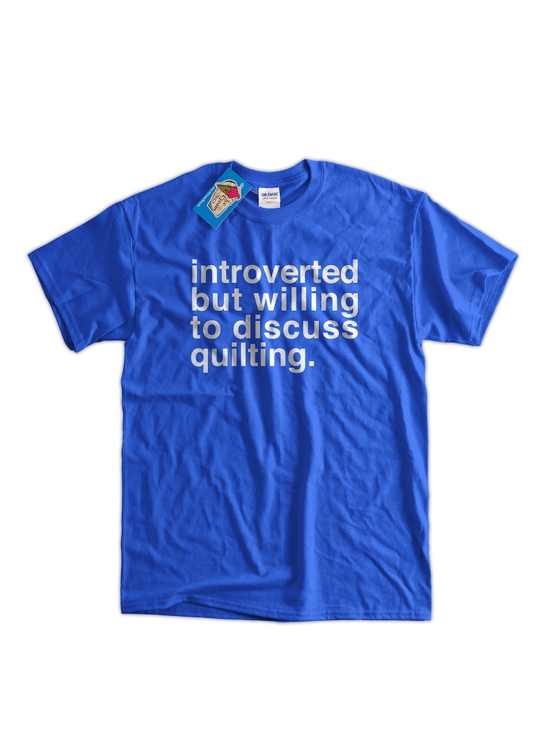 K&ouml;nnte beinhalten: Ein k&ouml;nigsblaues T-Shirt mit wei&szlig;em Text, der "introvertiert, aber bereit, &uuml;ber Quilten zu diskutieren" lautet.