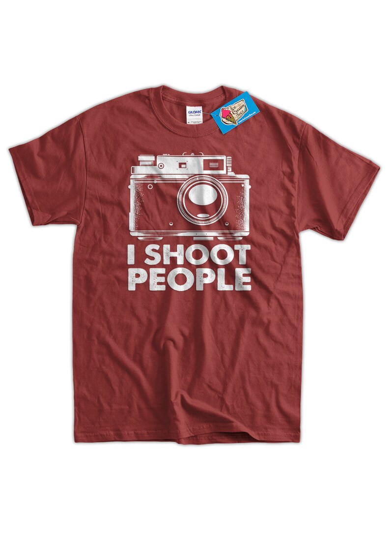 May include: Red t-shirt with a vintage camera graphic and the text "I shoot people".