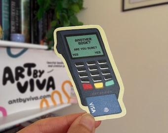 May include: A sticker featuring a cartoon illustration of a point-of-sale (POS) terminal with a credit card inserted. The screen reads "ANOTHER BOOK? ARE YOU SURE? YES YES". The terminal is dark blue with colorful buttons. A Visa card is inserted.