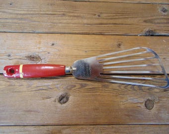 Batidora de acero "Ecko A&J" de la década de 1940 con mango de madera maciza pintado de rojo con efecto desconchado, curvada para adaptarse al tazón. Batidora de masa para pasteles vintage.