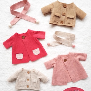 以下が含まれることがあります： ベージュ、ピンク、レッド、ブラウンなど、さまざまな色のフェルト製のドールコート4着。各コートにはボタン留めとポケットが付いています。コートは白い表面に配置され、各コートの隣にはピンクとベージュのフェルトのスカーフがあります。赤い円の中に白い文字で「pdf pattern」と書かれています。