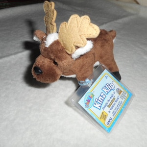 May include: Brown and white plush reindeer toy with brown antlers and a blue and white tag that says "Webkinz Klip Unlock the magic of Webkinz.  Discover a whole new world of fun!  Includes a Webkinz Klip code.  04817"