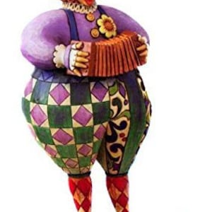 Può includere: Una statuetta di clown fantasiosa con un costume a scacchi viola e verde, un cappello rosso e bianco e un naso rosso. Il clown suona una fisarmonica marrone e ha un fiore sul petto.