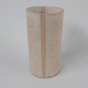 Könnte beinhalten: Eine weiße Keramikvase mit einem vertikalen Streifen in einer helleren Beigefarbe. Die Vase hat eine strukturierte Oberfläche.